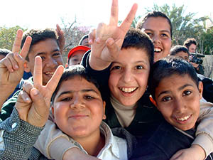 Iraqi boys giving the peace sign